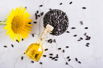 Sunflower oil in a bottle and seeds in a bowl on the table. Harvest and natural nutrition. Top view