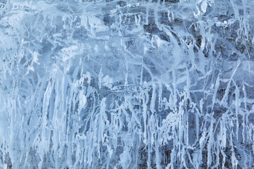 Texture of winter ice on a stone cliff. Blue natural ice background