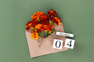 October 4. Bouquet of orange flower in craft envelope and calendar date on green background. Minimal concept Hello fall. Template for your design, greeting card