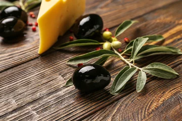 Foto op Plexiglas Tasty black olives and tree branch on wooden table, closeup © Pixel-Shot