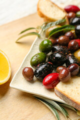 Plate of delicious olives on table, closeup