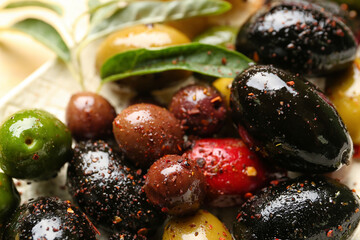 Different kinds of delicious olives with spices, closeup
