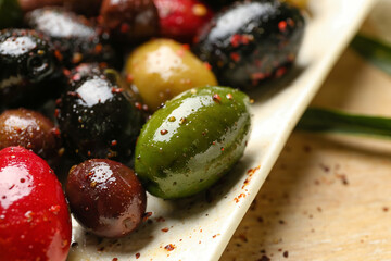 Plate with different kinds of delicious olives, closeup