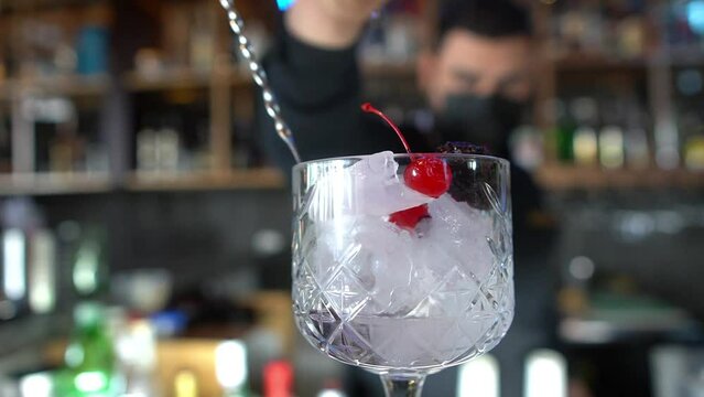 serving your ration of alcohol either rum, vodka or another to make a refreshing red fruit drink at a bar counter