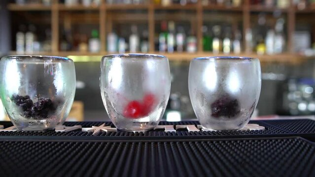 row of frozen glasses to prepare refreshing red fruit drinks ready to be served and refreshed in a bar counter