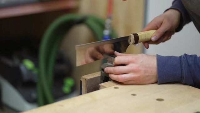 Luthier marking slots for attaching starting point of strings on fretboard on newly built electric resonator guitar. Close up.