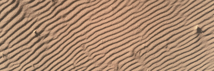 Sand texture with wave pattern. Desert sand background, top view