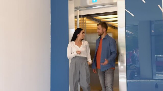 Confident business partners talking leaving the elevator
