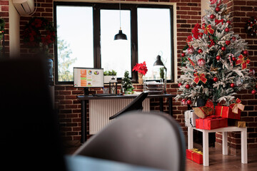 Empty business office with festive christmas decorations in company workplace. Seasonal winter holiday ornaments with lights and tree to celebrate xmas, no people in corporate job space.
