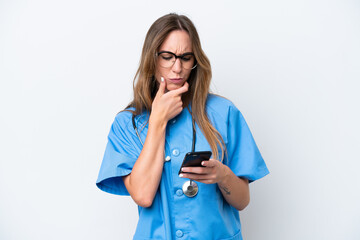 Young surgeon doctor woman isolated on blue background thinking and sending a message