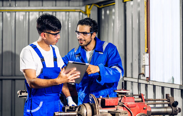 Professional two labor machanic engineer technician worker industrial man wearing blue safety uniform working control with heavy machine in manufacturing  factory production line.business industry