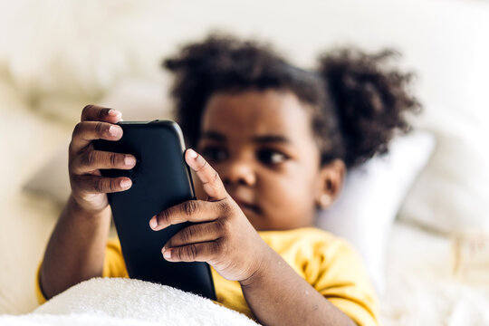 Portrait Of Happy Little Child African American Girl Using Digital Smartphone Playing Game Online And Social Media