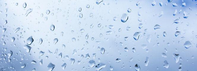 Background with drops, water drops on glass against the sky with clouds, selective focus