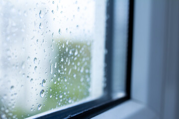 Drops on the glass close-up, rain outside the window, wet double-glazed window, selective focus