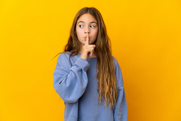 Child over isolated yellow background showing a sign of silence gesture putting finger in mouth - obrazy, fototapety, plakaty