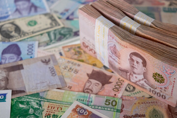 A pile of cash on international banknotes on a background