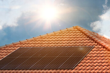 Solar panels on roof top of the residential house with sun light. Clean energy. Ecological concept