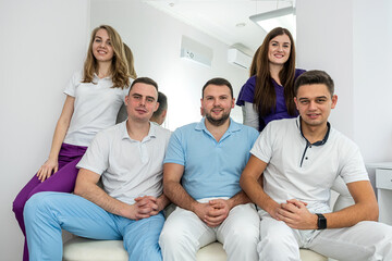 Beautiful young nice well-dressed dentists stand beautifully in their dental office.