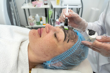 satisfied   woman uses the services of a professional cosmetologist in a beauty salon or spa.