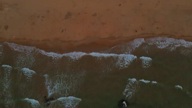 Aerial of foamy sea waves hitting the rocky beach of Kilyos in Istanbul