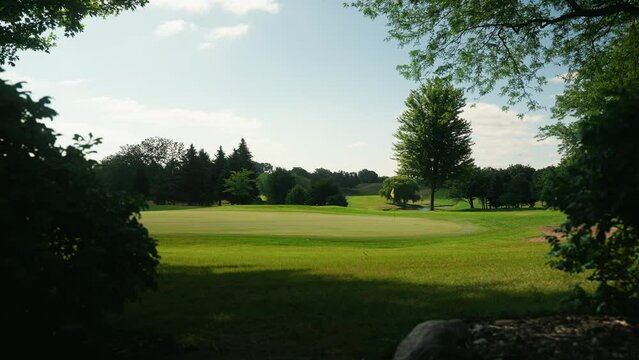 walking down a path to a green on a golf hole at a course on a sunny day