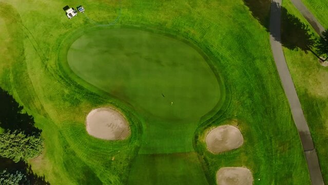 top down drone shot of a golf green with two front green side bunkers