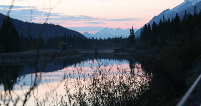 Beautiful landscape of a calm lake surrounded by mountains in Canmore, Alberta, Canada, at sunset