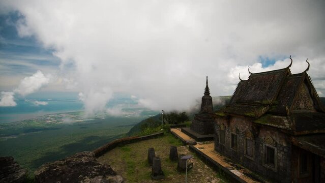Mystic old Buddhist pagoda in the sweeping wispy hillside clouds of Bokor mountain, Cambodia. Wat Sampov Pram, a main tourist attraction for local Khmer and tourists.