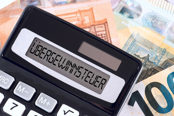 Übergewinnsteuer, Taschenrechner und Euro Geldscheine - obrazy, fototapety, plakaty