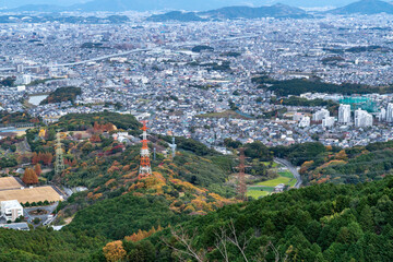 Electricity is carried by high-voltage lines on the hill close a city.