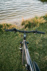 Fototapeta na wymiar POV bike handlebar with a nature backdrop. Leisure time in summer evening concept.