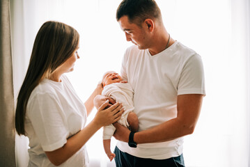 Newborn baby with happy parents. Happy family. Healthy newborn baby with mom and dad. Mother, father and infant baby. Cute Infant girl and parents