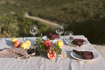 Table set with linen tablecloth and napkins for feast of Rosh Hashana, new Jewish year start , with traditional symbolic dishes and foods, pomegranate, Honey, Apple and wine. 