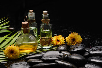 yellow flower .oil bottle  and zen black stones ,wet background
- 528391168