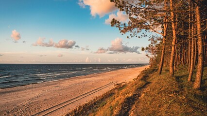 Baltic sea with a sandy beach during sunset with a blue sky in the background