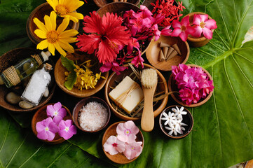 Spa setting with summer flower with salt ,soap in bowl on big leaf