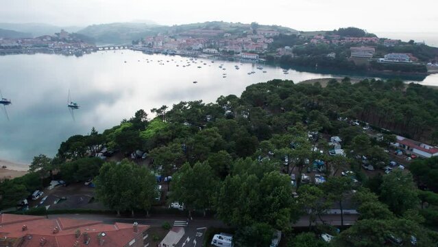 Aerial drone flying over San Vicente de la Barrera (North Spain). residential areas in the hills and close to a large lake. 4K Videos.