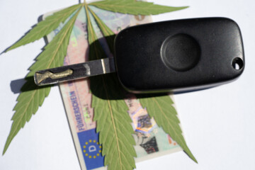 symbolisches Cannabisblatt mit Autoschlüssel und Führerschein - obrazy, fototapety, plakaty