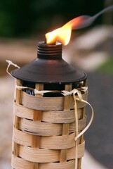 Vertical shot of a tiki torch burning on a beach