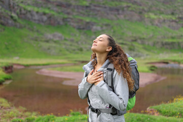 Hiker breathing with hands on chest in nature