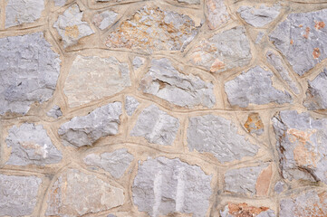 Simple textured light background of stone wall of aged building