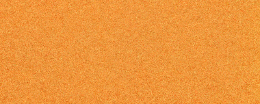 Texture of bright orange and red colors paper background, macro. Structure of dense ginger craft cardboard