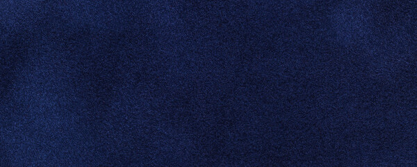 Navy blue suede fabric background, macro. Velvet matte texture of dark denim nubuck textile.