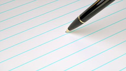 Close up ball point pen on blank blue line notebook paper. Blank paper with pen for creative design.