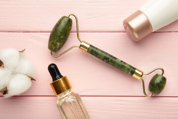 Jade facial roller on pink background with copy space © Mouse family