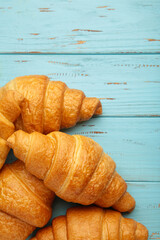 Freshly baked croissants on blue wooden background Warm Fresh Buttery Croissants and Rolls. French and American Croissants and Baked Pastries