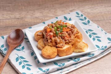 Fried tofu stir fried with ground pork and vegetables in white plate