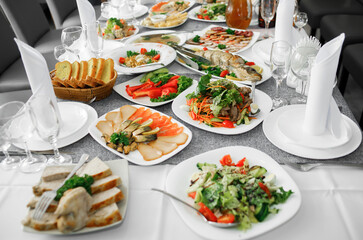 Fish dishes on the banquet table, logos, snacks, vegetables