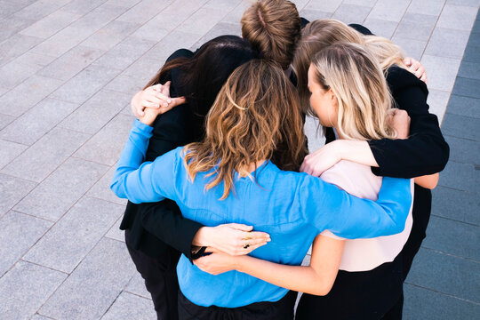 Business people standing in huddle on sunny day
