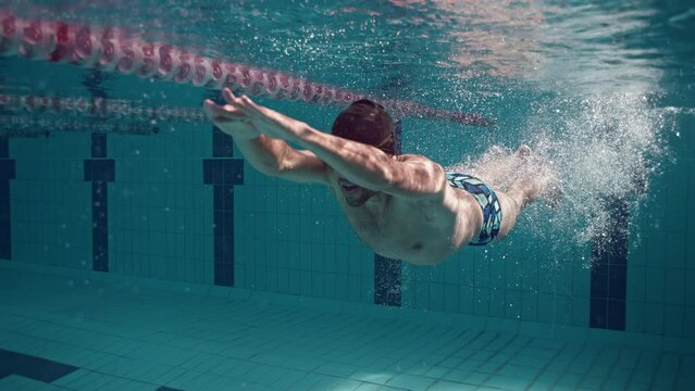 Slow Motion Professional Swimmer Underwater Pushing Wall And Swimming Freestyle, 4K